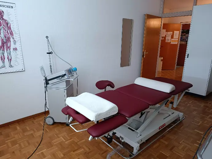 Salle de traitement avec table de massage et machine d'onde de choc